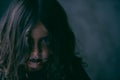 Wicked angry little caucasian girl with long curly hair wearing dark Halloween makeup on her beautiful face with copy space Royalty Free Stock Photo