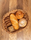 Wicker basket with assorted bakery products including loafs of bread and rolls Royalty Free Stock Photo