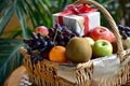 wicker basket with assorted fruits and a wrapped gift on top Royalty Free Stock Photo