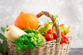Wicker basket with autumn fruits and vegetables on grey background Royalty Free Stock Photo