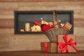 Wicker basket with bottle of wine and gift boxes on table in room Royalty Free Stock Photo