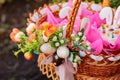 Wicker basket with bright painted Easter eggs and spring flowers Royalty Free Stock Photo