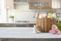 Wicker basket with bunny, tulip, easter colorful eggs on kitchen wooden table. Spring easter composition. Space for text Royalty Free Stock Photo