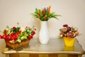 Wicker basket with decorative flowers. White vase with wildflowers. Yellow pot with flowers on the table. Royalty Free Stock Photo