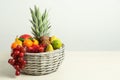 Wicker basket with different fresh fruits on white wooden table. Space for text Royalty Free Stock Photo