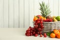 Wicker basket with different fresh fruits on white wooden table. Space for text Royalty Free Stock Photo