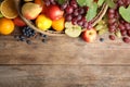 Wicker basket with different fruits and berries on wooden table, flat lay. Space for text Royalty Free Stock Photo