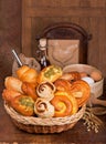 Wicker basket with different types of bread on wooden table. Royalty Free Stock Photo