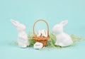 Wicker basket and easter bunny, words like love, luck and joy are standing in german language on the pebbles, rabbit brings gift