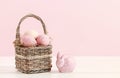 Wicker basket with Easter eggs and ceramic rabbit figure Royalty Free Stock Photo