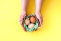Wicker basket with Easter eggs in the hands Royalty Free Stock Photo