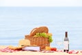 Wicker basket with food and wine on beach. Summer picnic Royalty Free Stock Photo