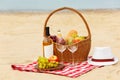 Wicker basket with food and wine on beach. Summer picnic Royalty Free Stock Photo