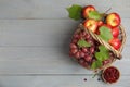 Wicker basket with fresh fruits and berries on grey wooden table, flat lay. Space for text Royalty Free Stock Photo