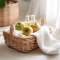 Wicker basket with fresh green apples, bottles of oil and towels