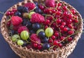 Wicker basket with fresh ripe berries: raspberries, gooseberries, blackberries Royalty Free Stock Photo