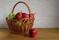 A wicker basket of fruit, apples and pears on the table. Royalty Free Stock Photo