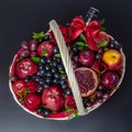 Wicker basket with fruit and a bottle of wine, beautifully decorated on a dark background. concept., congratulations for a holiday Royalty Free Stock Photo