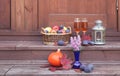 Basket with fruits, rose champagne, lantern, figs, pumpkin and purple spirea are on steps of rustic wooden ladder