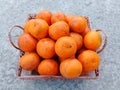 A wicker basket full of fresh orange fruits on the floor Royalty Free Stock Photo
