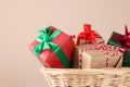 Wicker basket full of gift boxes on beige background, closeup Royalty Free Stock Photo