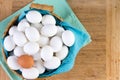 Wicker basket full of white eggs with one brown Royalty Free Stock Photo