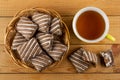 Wicker basket with gingerbread, broken gingerbread, yellow cup with tea on table. Top view Royalty Free Stock Photo