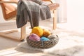 Wicker basket with knitting yarn near rocking chair indoors Royalty Free Stock Photo