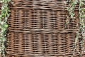 Wicker basket with leaves falling down on the sides, background.