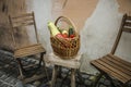 Wicker basket with mixed organic vegetables on wooden chair Royalty Free Stock Photo