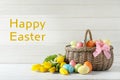 Wicker basket with painted Easter eggs and spring flowers Royalty Free Stock Photo