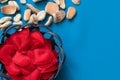 Wicker basket or plate containing fabric bright red hearts on a blue woven background with seashells and fossils in the background Royalty Free Stock Photo