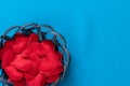 Wicker basket or plate in which fabric bright red hearts lie on a blue woven background for Valentine`s day February 14 and copy Royalty Free Stock Photo