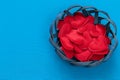 Wicker basket or plate in which fabric bright red hearts lie on a blue woven background for Valentine`s day February 14 and copy Royalty Free Stock Photo