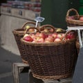 The Wicker basket of red apples with a price tag on the market for sale Royalty Free Stock Photo