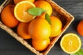 Wicker basket with ripe oranges on wooden table Royalty Free Stock Photo