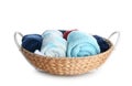 Wicker basket with rolled towels and clothes on white background Royalty Free Stock Photo