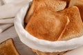 Wicker basket with slices of delicious toasted bread on white wooden table, closeup Royalty Free Stock Photo