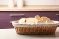 Wicker basket with  of tasty fresh bread on wooden table in kitchen Royalty Free Stock Photo