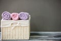 Wicker basket with towels on wooden table against grey background Royalty Free Stock Photo