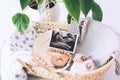 Wicker basket with ultrasound images and stuff for newborn baby