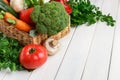 Wicker basket with vegetable assortment on wooden table Royalty Free Stock Photo