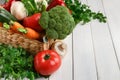 Wicker basket with vegetable assortment on wooden table Royalty Free Stock Photo