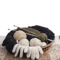 Wicker basket with wool balls, needles and knitted gloves