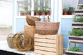 Wicker baskets next to the garden equipment against the wall of a blue country house. Summer seasonal vacation. Garden plants in p Royalty Free Stock Photo