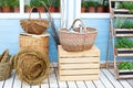 Wicker baskets next to the garden equipment against the wall of a blue country house. Summer seasonal vacation. Garden plants in p Royalty Free Stock Photo