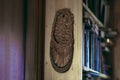 Wicker bast shoes hanging on a wooden bookshelf Royalty Free Stock Photo