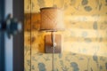 wicker bedside lamp casting patterned shadows on wall