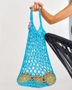 wicker blue bag with oranges in the girl's hand on