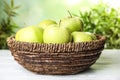 Wicker bowl of fresh ripe green apples on wooden table against blurred background Royalty Free Stock Photo